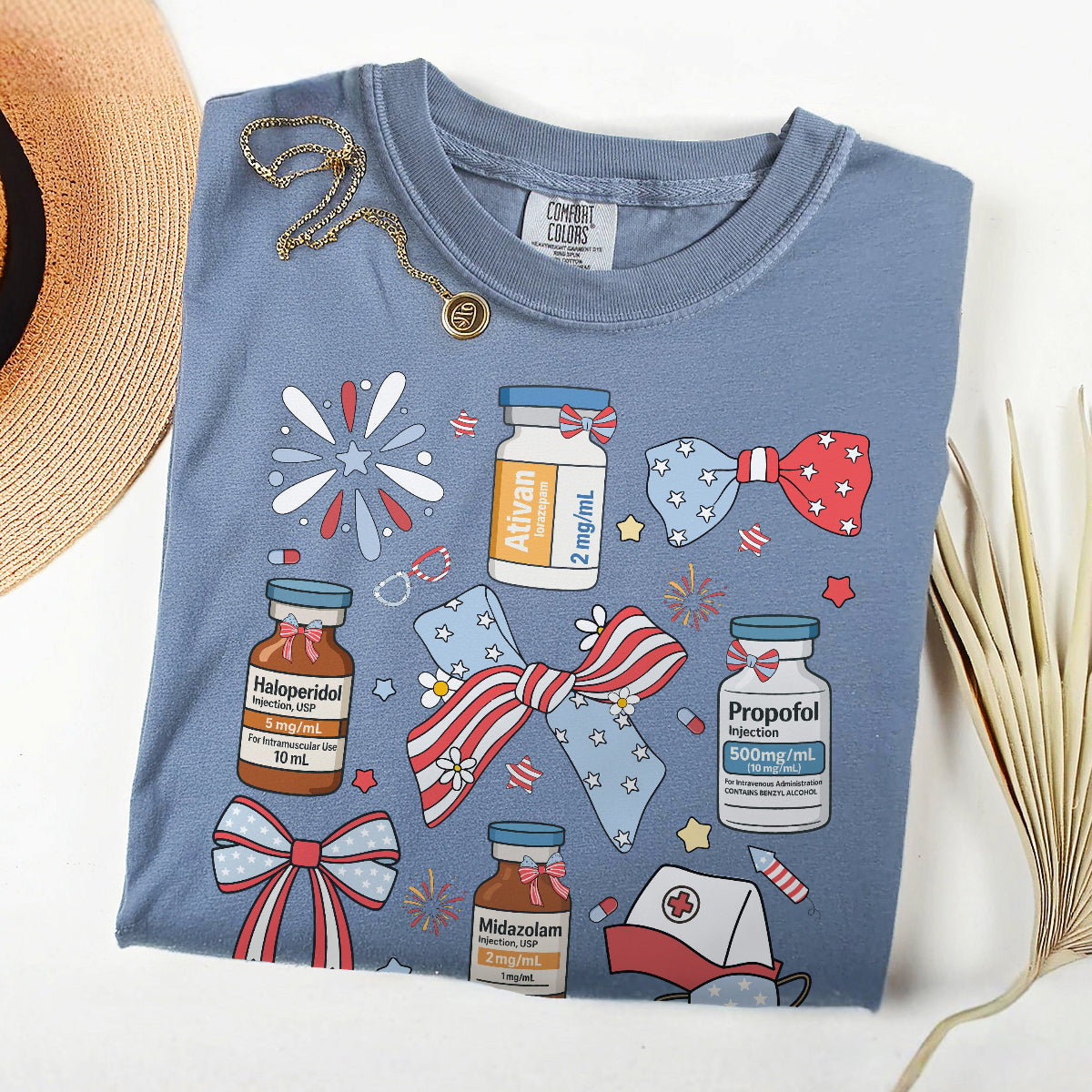 Blue t-shirt with medical-themed graphics and a straw hat on a white background
