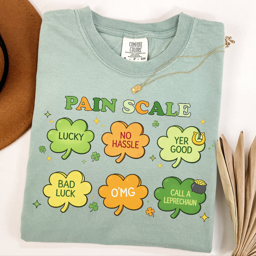 Light green t-shirt with colorful 'Pain Scale' design featuring shamrock shapes and text.

