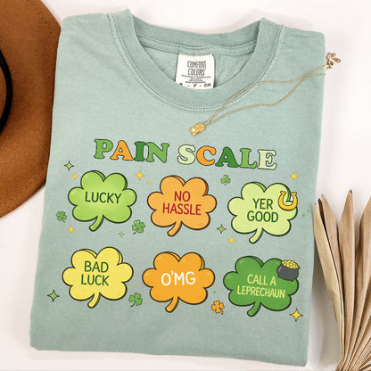 Light green t-shirt with colorful 'Pain Scale' design featuring shamrock shapes and text.

