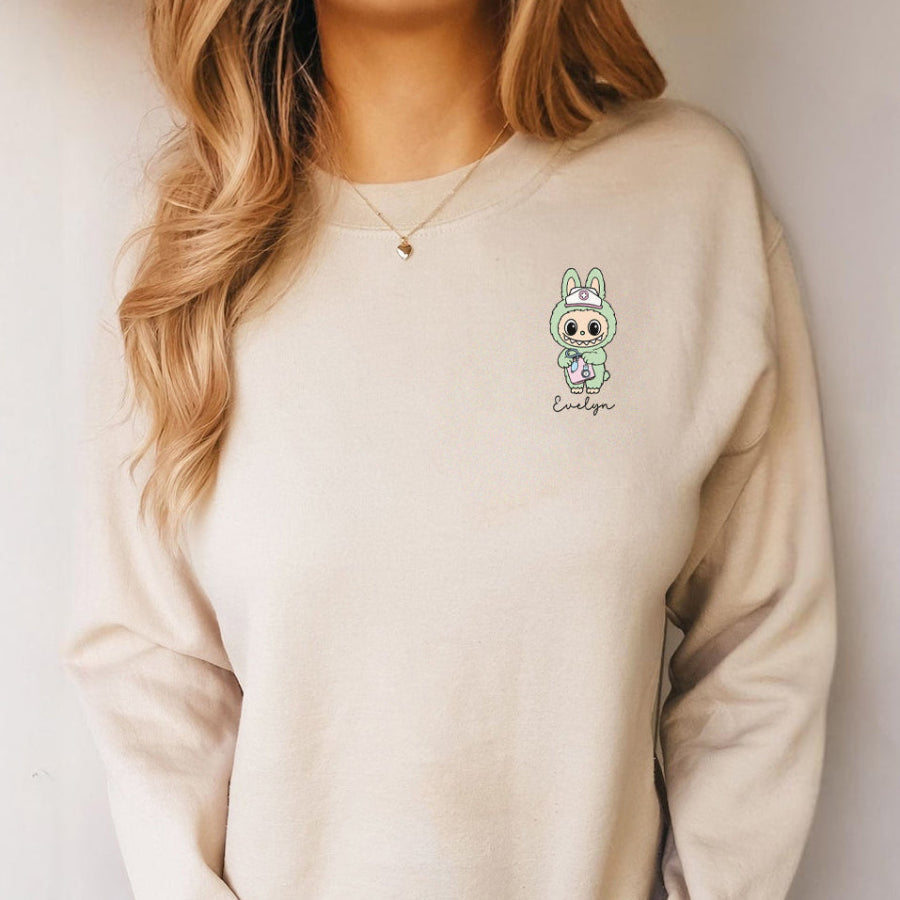 Beige sweatshirt with a cartoon character and text on a plain background