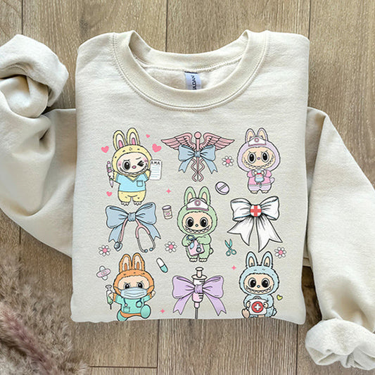 Folded cream-colored sweatshirt with cartoon character design on a wooden surface