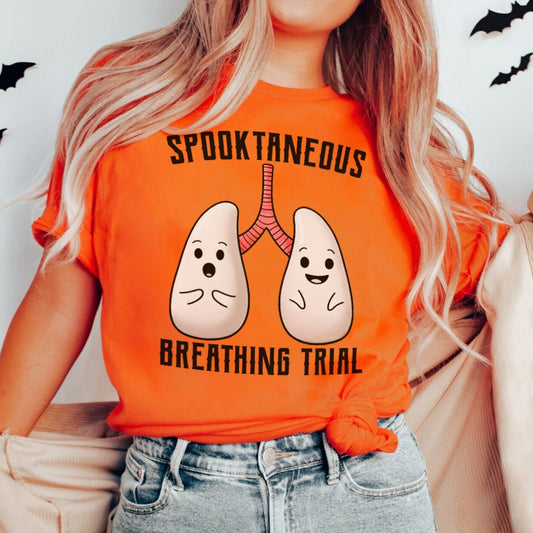 Person wearing an orange t-shirt with a graphic design and text, standing against a plain background.